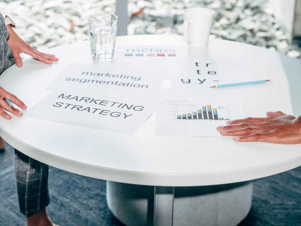 Two professionals collaborate on marketing strategy and segmentation at a round table.