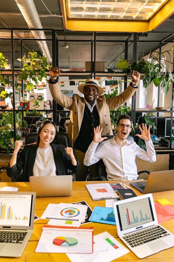 Crafting Captivating Headlines: Your awesome post title goes here Happy diverse team celebrating success in a modern office with laptops and charts.
